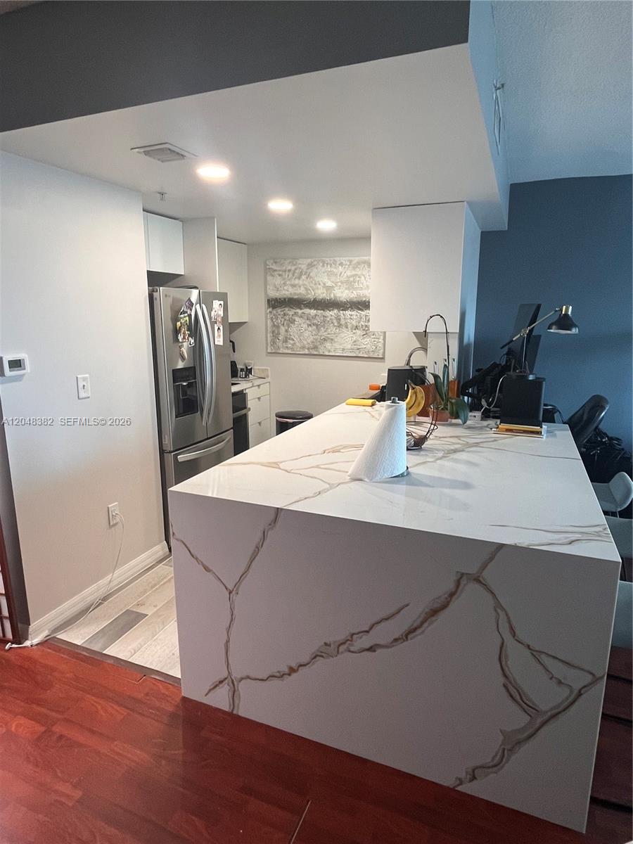 A kitchen features a large white marble-patterned waterfall island and stainless steel appliances — 275 NE 18th St # 1109, Miami FL 33132, MIAMI, FL