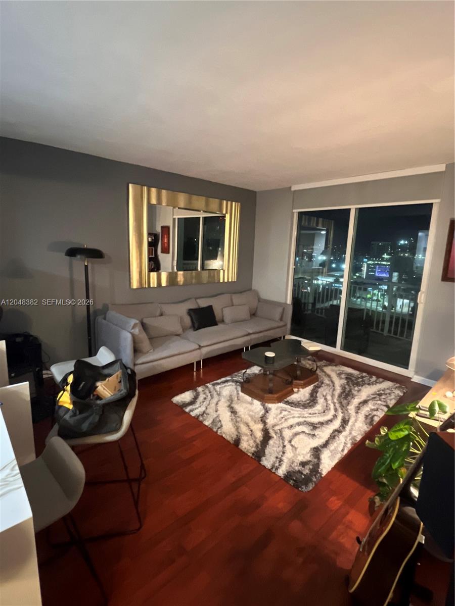 A living room features a gray sofa, a patterned rug, and a large gold-framed mirror — 275 NE 18th St # 1109, Miami FL 33132, MIAMI, FL