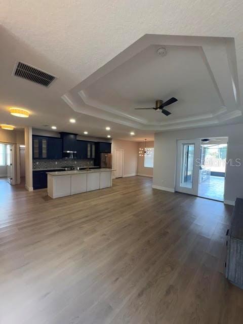 An open-concept kitchen with dark blue cabinets and a white island overlooks a living area — 123 BICKFORD DRIVE, PALM COAST, FL