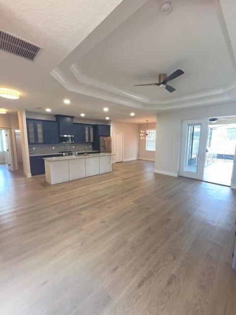 A kitchen with dark blue cabinets and a white island sits in a large room — 123 BICKFORD DRIVE, PALM COAST, FL
