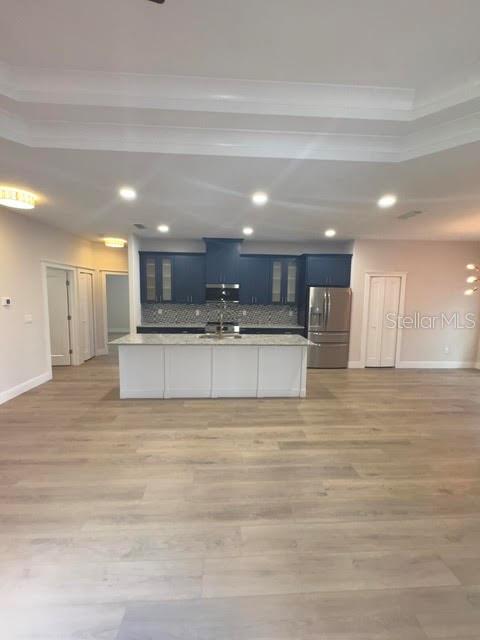 A kitchen features a white island, dark blue cabinetry, and light wood flooring — 123 BICKFORD DRIVE, PALM COAST, FL