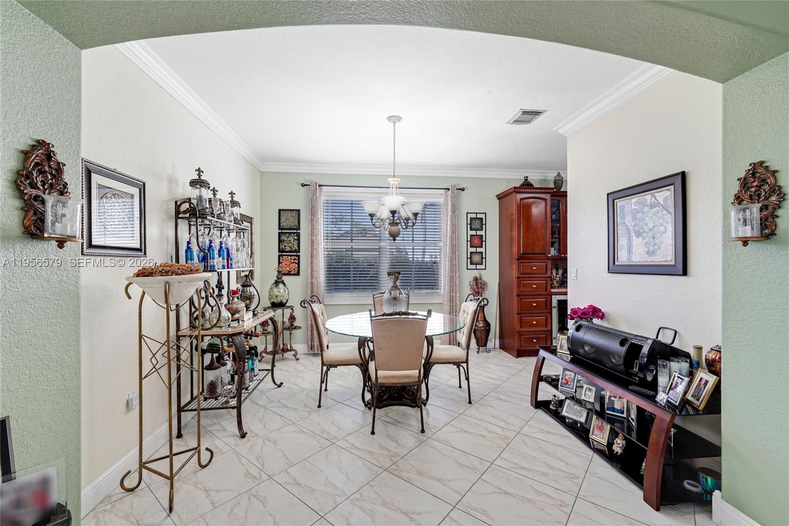 A dining room features a glass-topped table, tile flooring, and a wooden hutch — 2250 SW 155th Ave, Miami FL 33185, MIAMI, FL