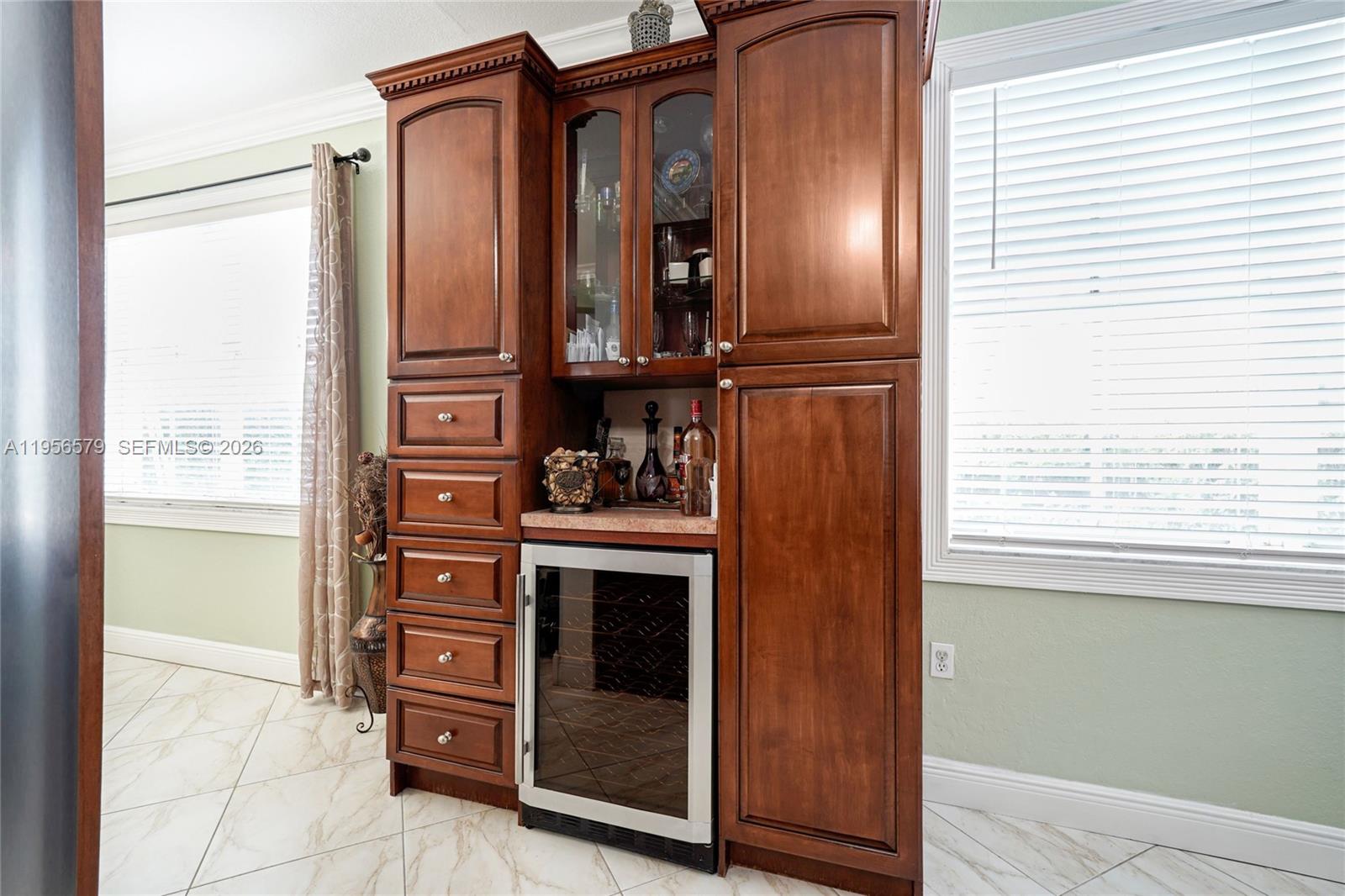 A wooden built-in bar cabinet features a wine cooler, glass-front display, and storage drawers — 2250 SW 155th Ave, Miami FL 33185, MIAMI, FL