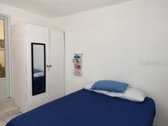 A bedroom features a white wardrobe with a mirror and a bed with blue bedding — Carr 900 PARCELAS NUEVAS, YABUCOA, PR