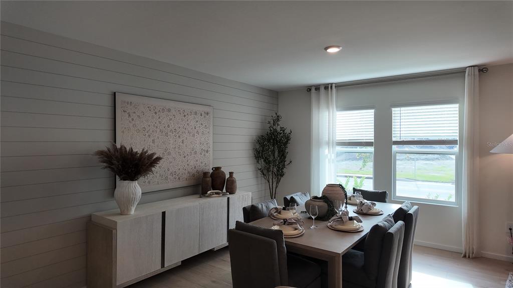 A dining room features a shiplap accent wall, a sideboard, and a six-chair table — 4443 ELLIOTS ASTOR BOULEVARD, ST CLOUD, FL