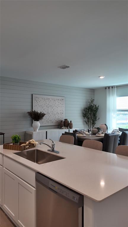 A kitchen island with a stainless steel sink overlooks a dining area with shiplap walls — 4443 ELLIOTS ASTOR BOULEVARD, ST CLOUD, FL