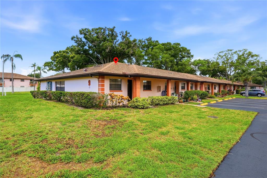 A single-story residential building with a tan exterior and a brown shingled roof — 13250 RIDGE ROAD UNIT 9-1, LARGO, FL