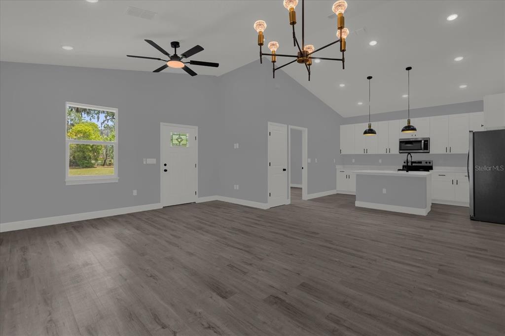 This is a digital rendering of an open-concept living room and kitchen with gray flooring — 1126 S THOMPSON AVENUE, DELAND, FL