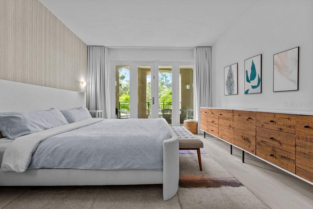 A bedroom features a white bed, a wooden dresser, and glass doors leading to a balcony — Ocean Sixteen 9000 RIO MAR BLVD UNIT 321, RIO GRANDE, PR