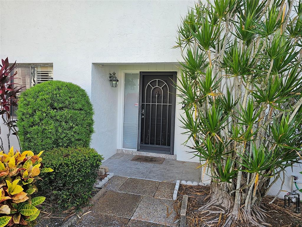 A front entryway features a dark door with a decorative screen and a tiled porch — 3500 EL CONQUISTADOR PARKWAY UNIT 275, BRADENTON, FL