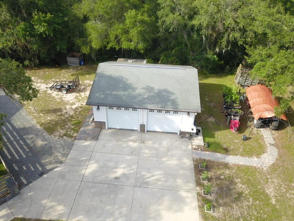 An aerial view shows a detached two-car garage with a shingled roof and concrete driveway — 25962 WHIPPERWILL STREET, BROOKSVILLE, FL