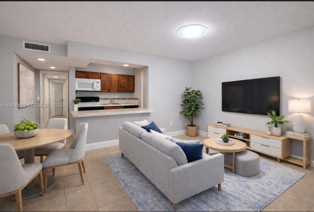 This living room features a dining area, an open kitchen, and neutral tile flooring — 850 SW 129th Pl # 103, Miami FL 33184, MIAMI, FL