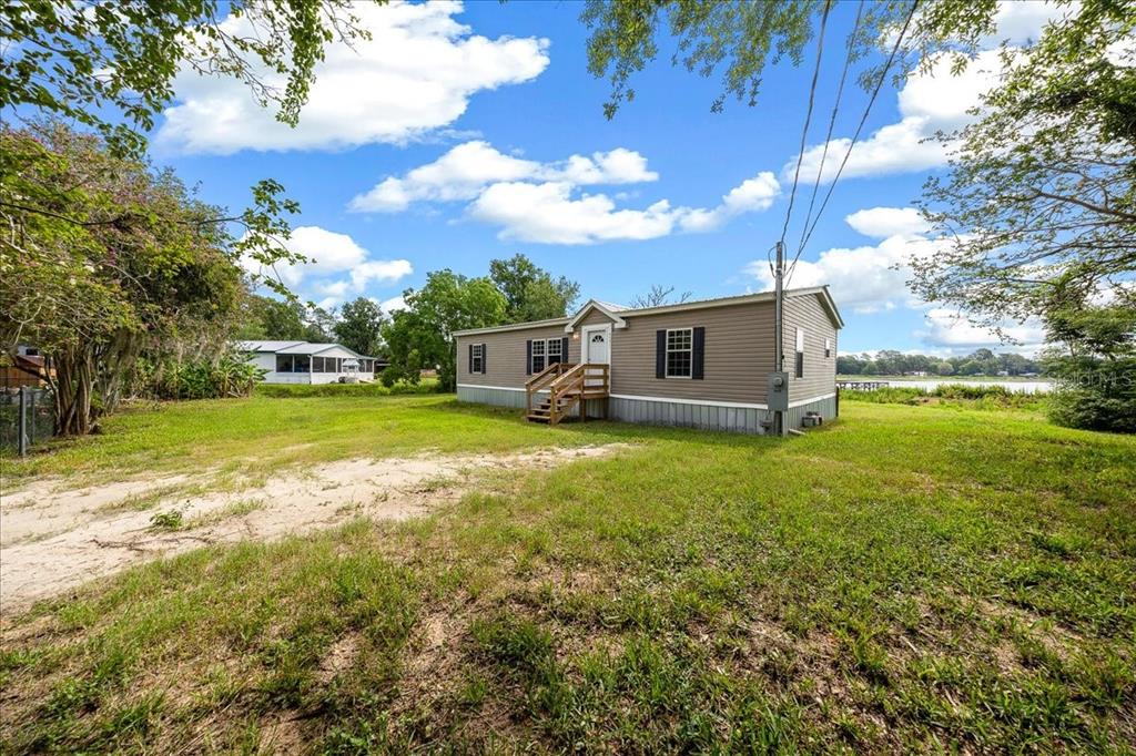 A single-story manufactured home sits on a grassy lot with a dirt driveway — 8581 NE 147TH COURT, SILVER SPRINGS, FL