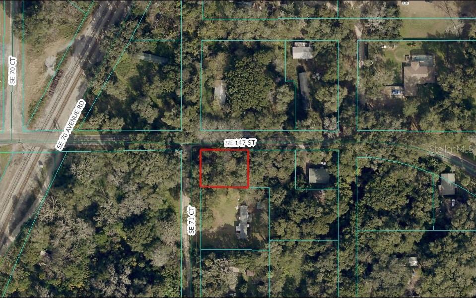 This is an aerial map showing a vacant, wooded lot outlined in red — TBD SE 147TH STREET, SUMMERFIELD, FL