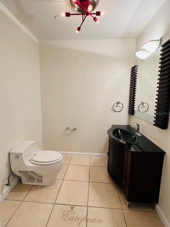 A bathroom features a white toilet, a dark vanity with a black sink, and tile flooring — 101 PALM HARBOR PARKWAY UNIT A404, PALM COAST, FL