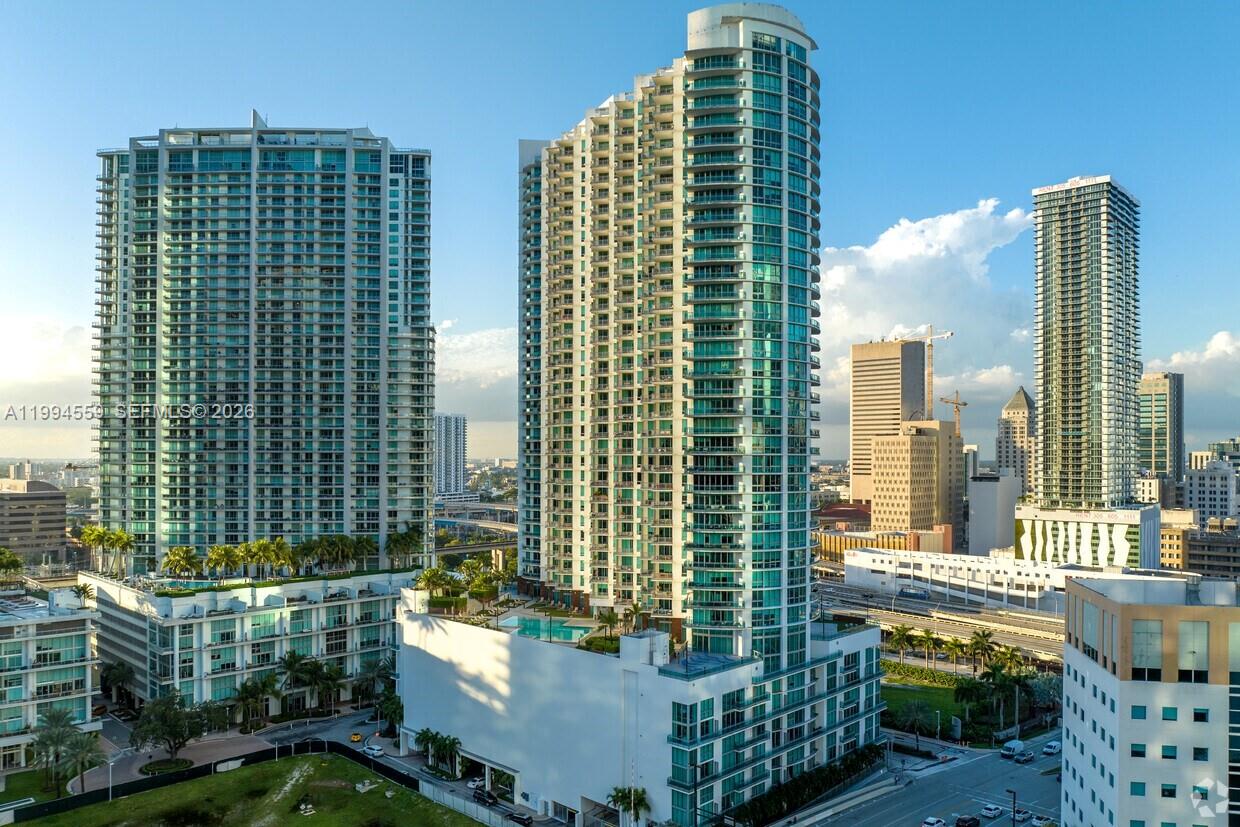 An aerial view shows two tall glass residential towers with a swimming pool deck below — 350 S Miami Ave # 2714, Miami FL 33130, MIAMI, FL