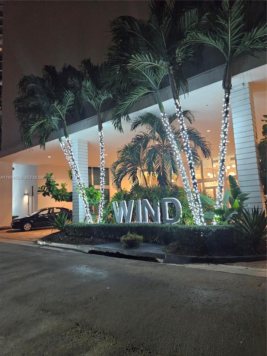 The exterior entrance of a building features a large sign reading WIND and illuminated palm trees — 350 S Miami Ave # 2714, Miami FL 33130, MIAMI, FL