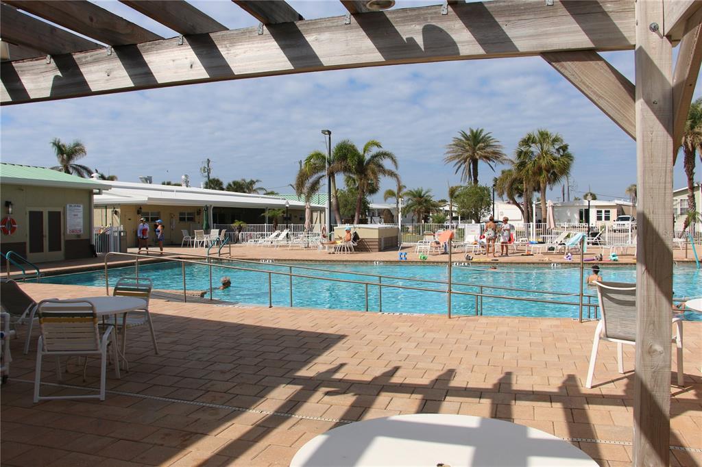 A swimming pool with a metal railing and surrounding patio area under a wooden pergola — 808 S GREEN CIRCLE, VENICE, FL