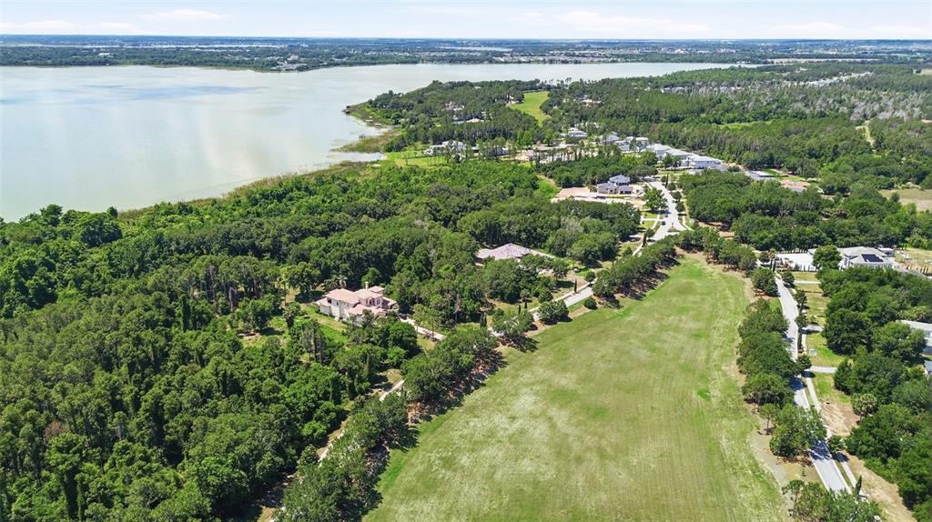 An aerial view shows a large house surrounded by dense trees near a lake — 17119 ETRUSCAN LANE, MONTVERDE, FL