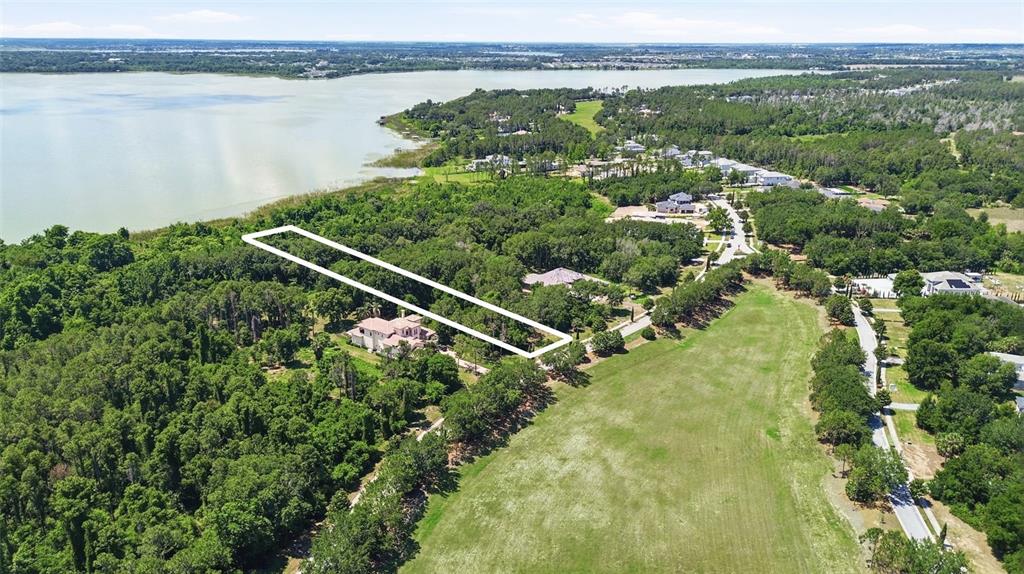 An aerial view shows a rectangular property outline over a wooded lot near a lake — 17119 ETRUSCAN LANE, MONTVERDE, FL