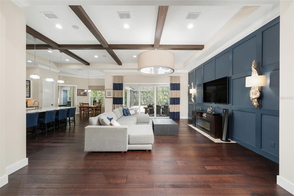 A living room features dark wood floors, a blue paneled accent wall, and coffered ceilings — 14205 9TH TERRACE NE, BRADENTON, FL