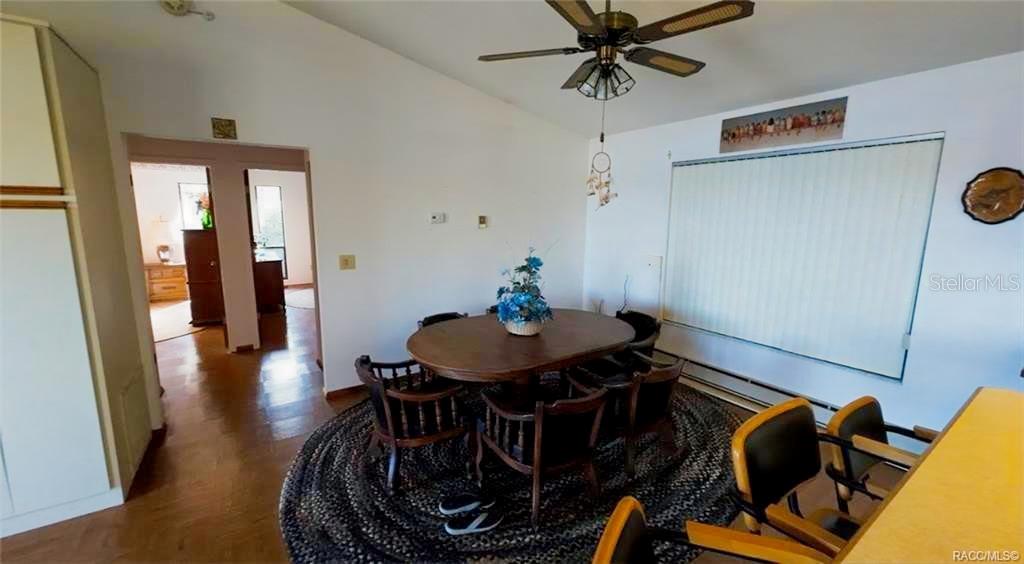 A dining room features a wooden table, chairs, a ceiling fan, and a braided rug — 5340 BLOUNT ISLAND, HOMOSASSA, FL