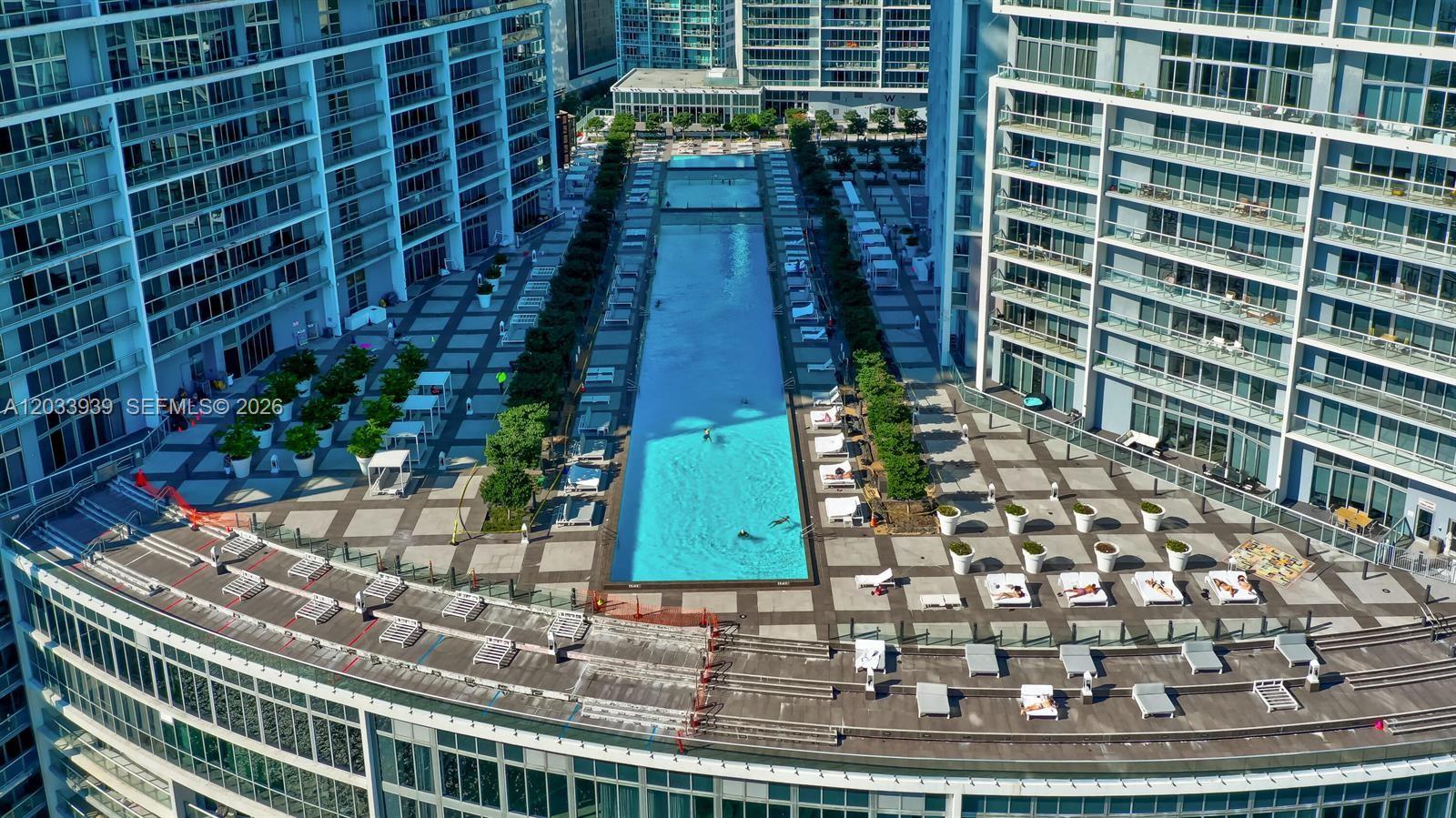 An aerial view shows a long rectangular swimming pool situated between two high-rise buildings — 485 Brickell Ave # 3109, Miami FL 33131, MIAMI, FL