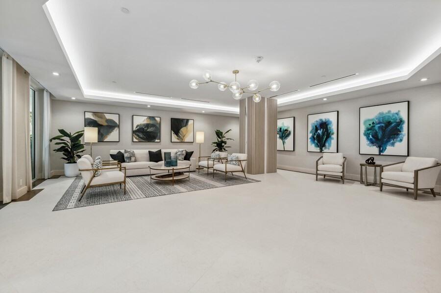 A spacious, modern lobby features white tile floors, neutral seating, and abstract wall art — 86 Macfarlane Drive # 8f, Delray Beach FL 33483, DELRAY BEACH, FL