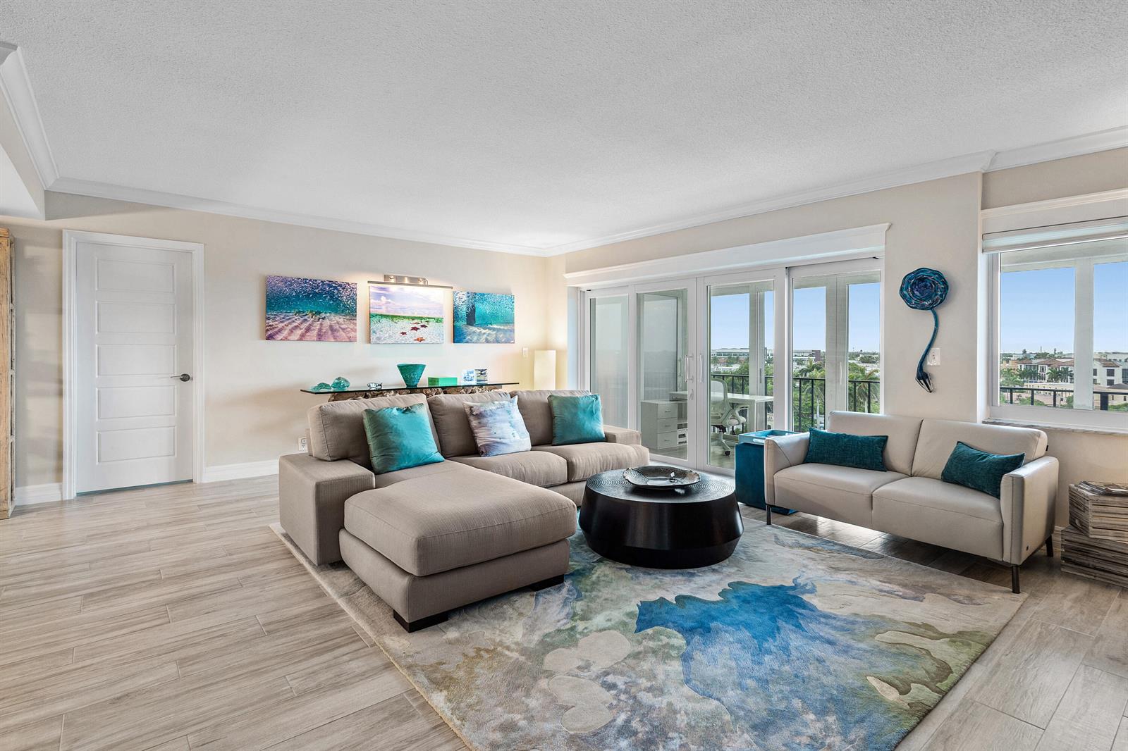 A living room features a sectional sofa, a loveseat, a round coffee table, and balcony views — 86 Macfarlane Drive # 8f, Delray Beach FL 33483, DELRAY BEACH, FL