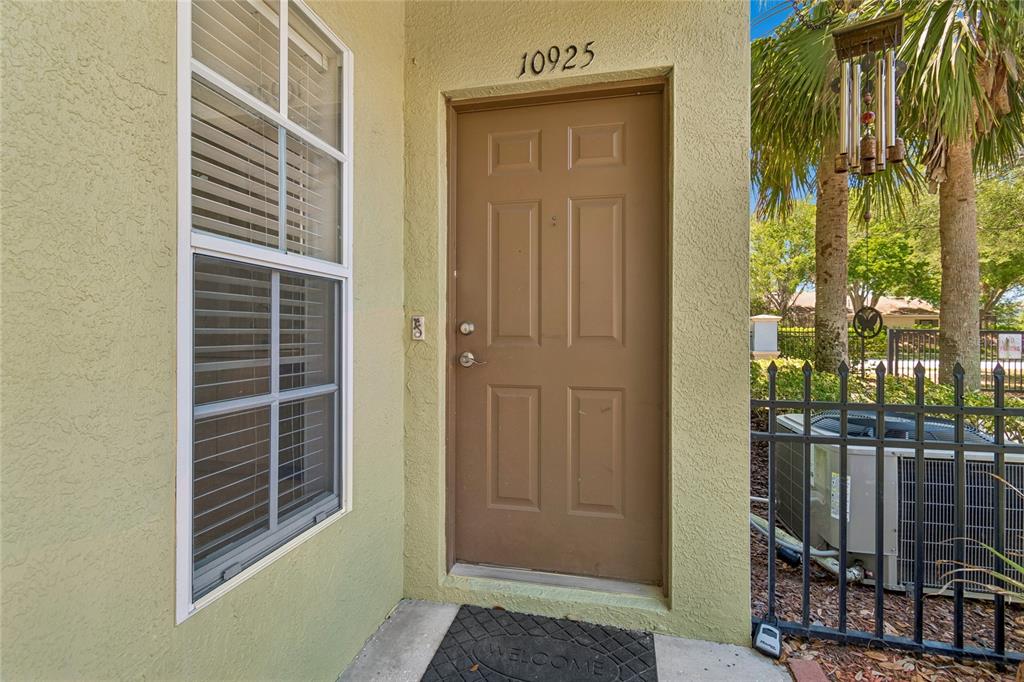 A tan exterior door with the number 10925 above it sits beside a window — 10925 WINTER CREST DRIVE, RIVERVIEW, FL
