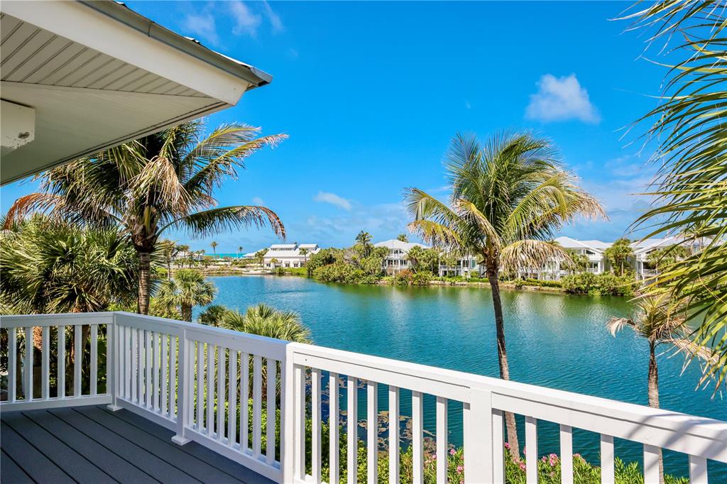 A view from a balcony overlooking a lake surrounded by palm trees and white houses — 760 SEABOARD LINE LANE, BOCA GRANDE, FL