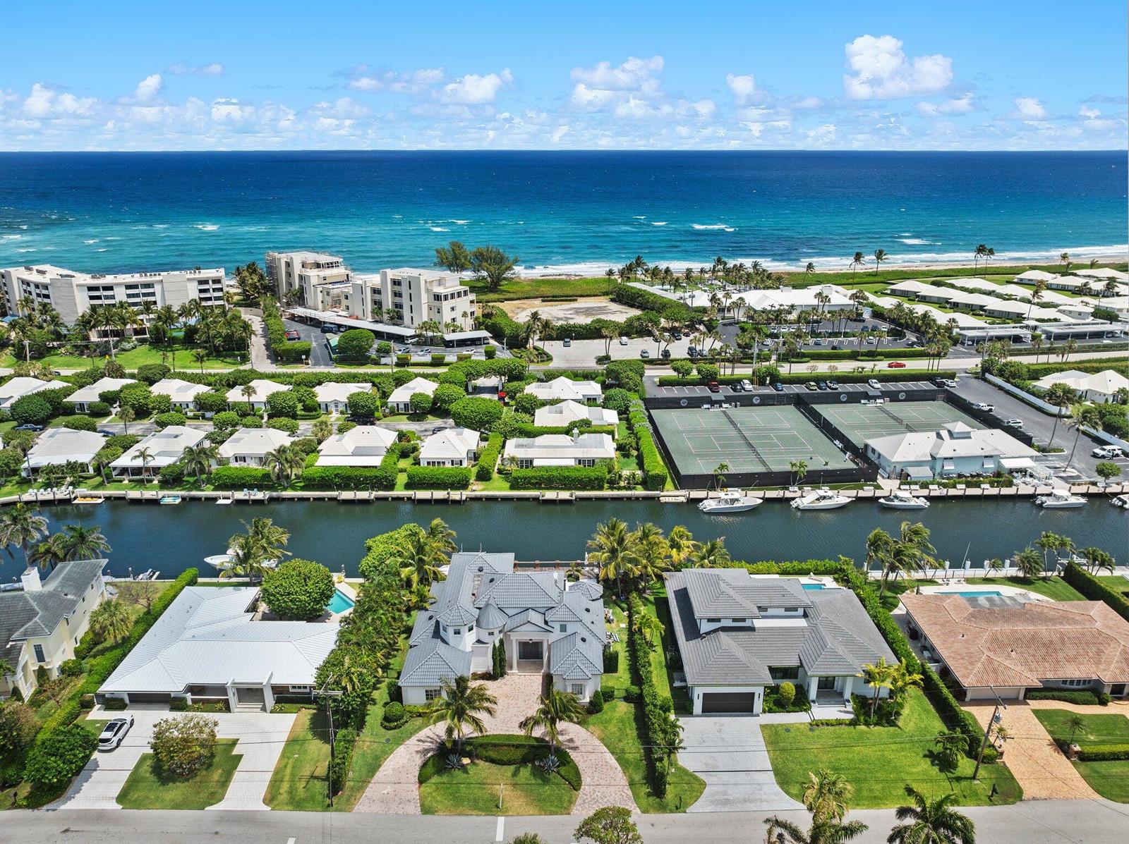 An aerial view shows waterfront homes with private docks, tennis courts, and the ocean beyond — 81 S Island Dr, Ocean Ridge FL 33435, OCEAN RIDGE, FL