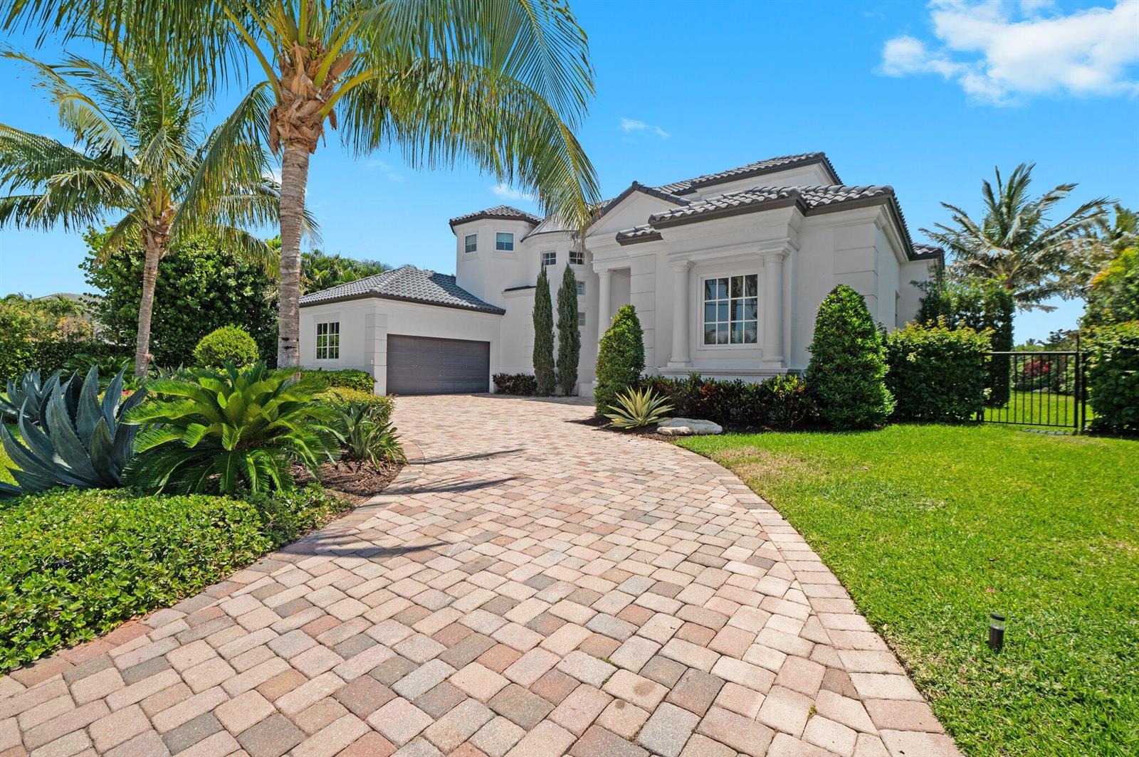 A paved driveway leads to the front entrance and garage of a white stucco house — 81 S Island Dr, Ocean Ridge FL 33435, OCEAN RIDGE, FL