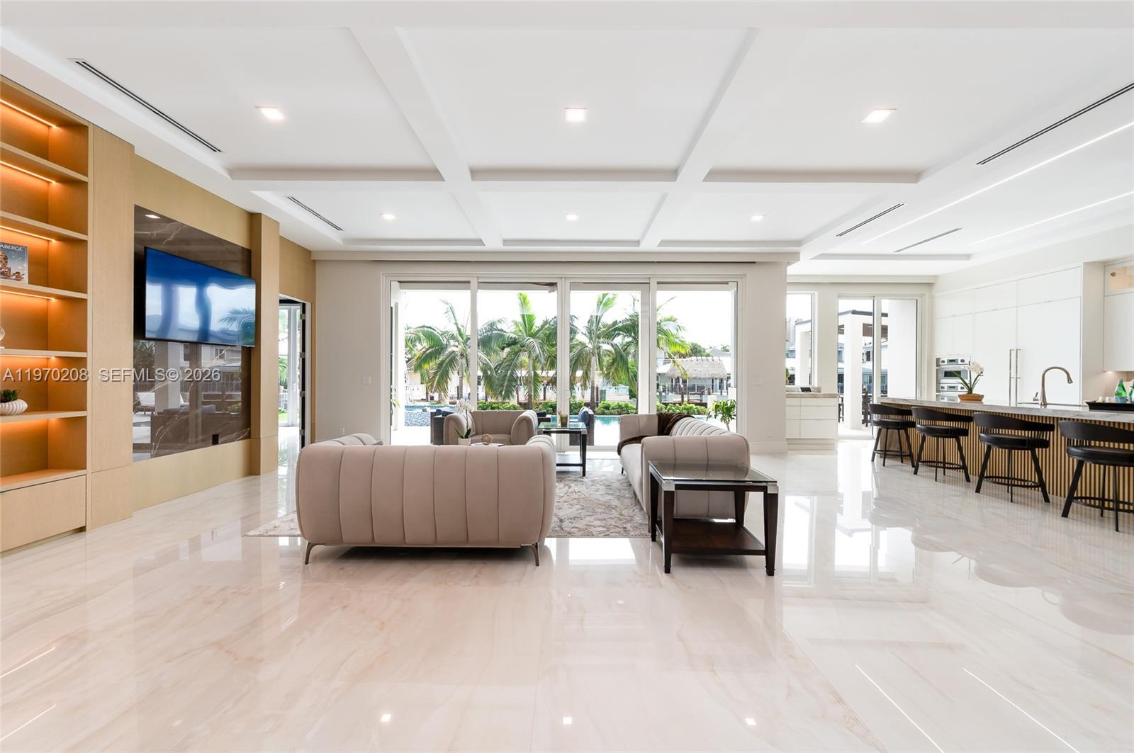 A modern open-concept living room features a marble floor, coffered ceiling, and a kitchen island — 3740 NE 29th Ave, Lighthouse Point FL 33064, LIGHTHOUSE POINT, FL