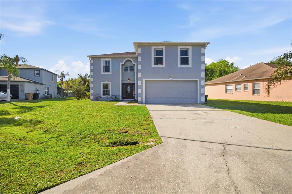 A two-story house with a gray exterior, white trim, and an attached two-car garage — 206 TARANTO WAY, KISSIMMEE, FL