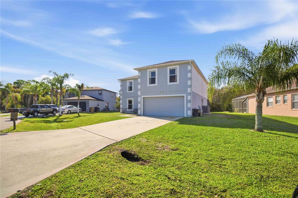 A two-story house with a gray exterior and a two-car garage sits on a lawn — 206 TARANTO WAY, KISSIMMEE, FL