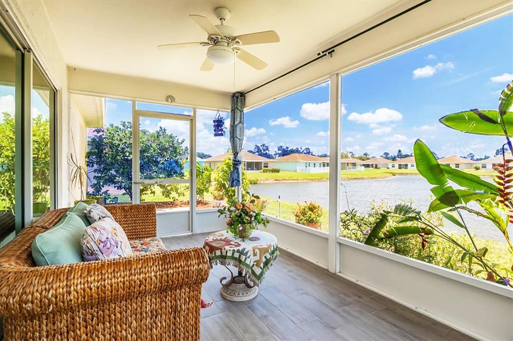 A screened-in porch with wicker furniture, a ceiling fan, and a view of a lake — 3215 55TH STREET E, PALMETTO, FL