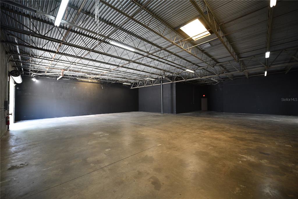 An empty warehouse space features black walls, a concrete floor, and an exposed metal ceiling — 1211 TECH BOULEVARD UNIT 169, TAMPA, FL