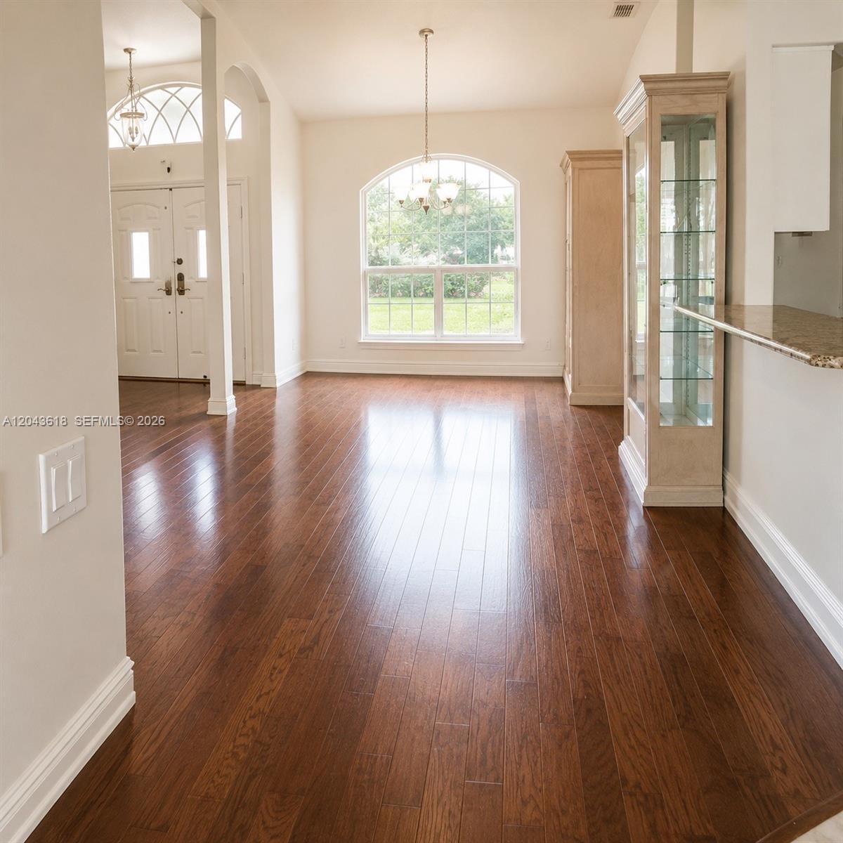 A dining area features hardwood floors, a large arched window, and a glass display cabinet — 16321 S Fiscus, Spring Hill FL 34610, SPRING HILL, FL