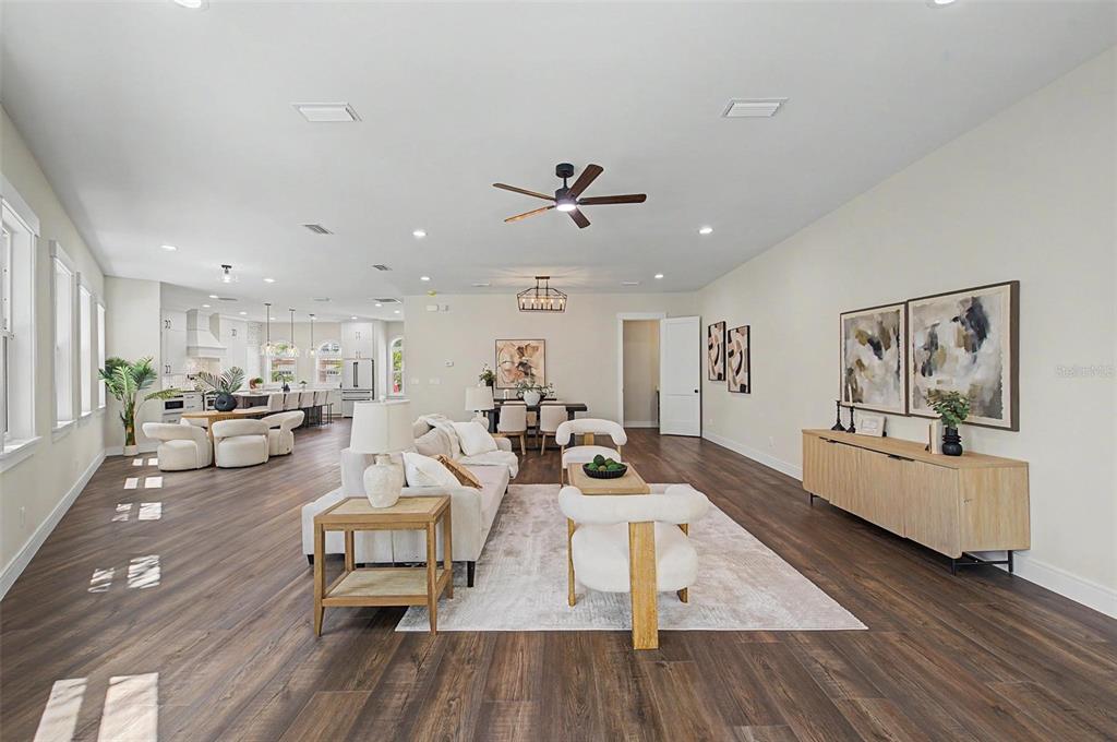 A spacious open-concept living room features wood-look flooring, a white sofa, and a dining area — 110 S ARRAWANA AVENUE UNIT 2, TAMPA, FL