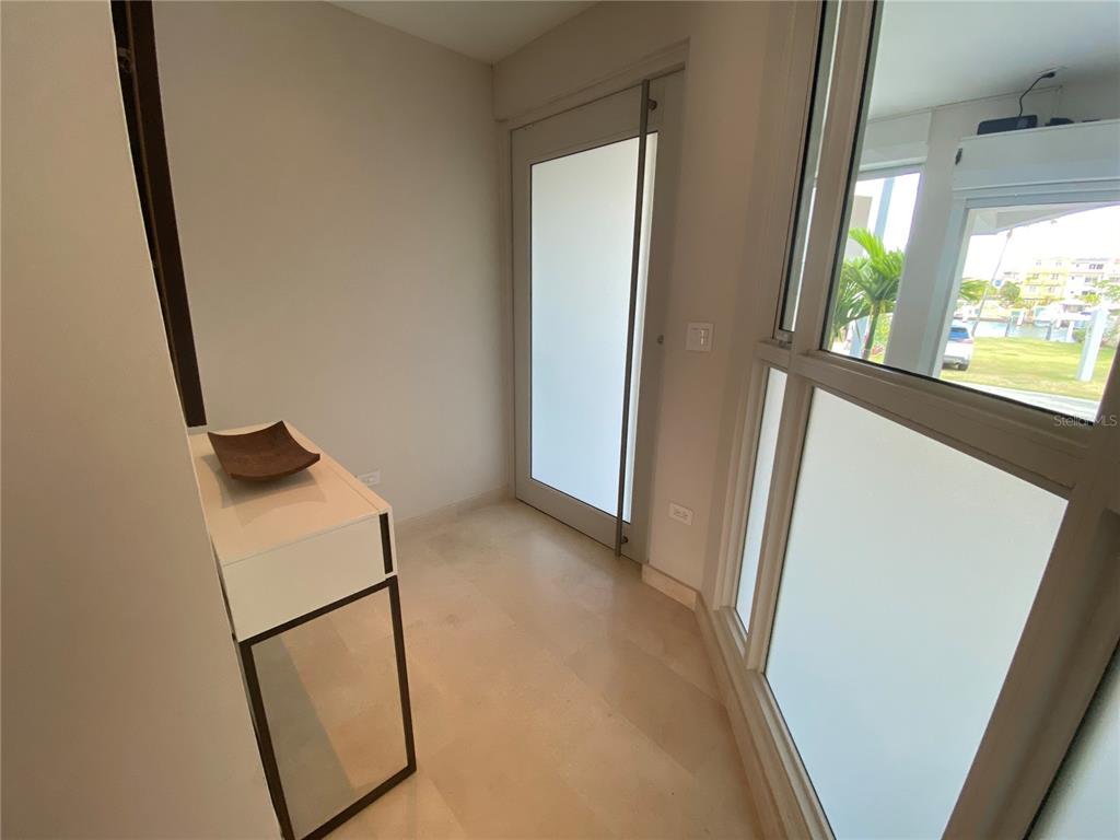 A bright entryway features a white console table, tile flooring, and a glass door — 14 PENINSULA  DE SAN JUAN STREET, HUMACAO, PR