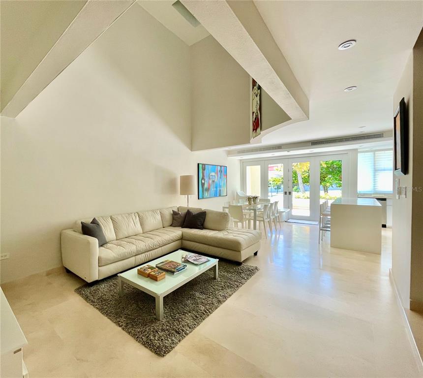 A bright living room features a white sectional sofa, a coffee table, and dining area — 14 PENINSULA  DE SAN JUAN STREET, HUMACAO, PR