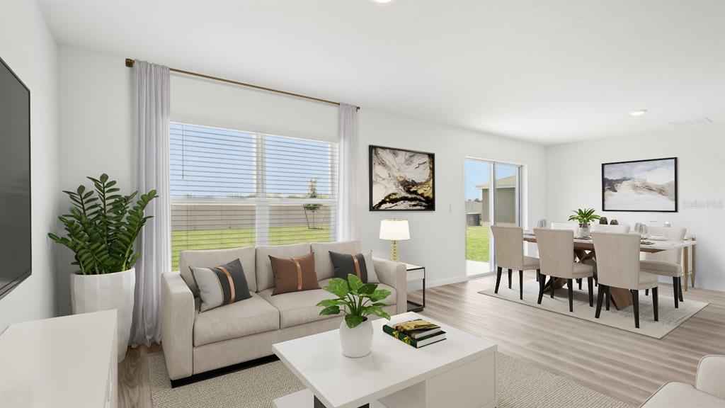 This rendering shows a living and dining area with light wood floors and neutral furniture — 1134 BOURBON AVENUE, PARRISH, FL