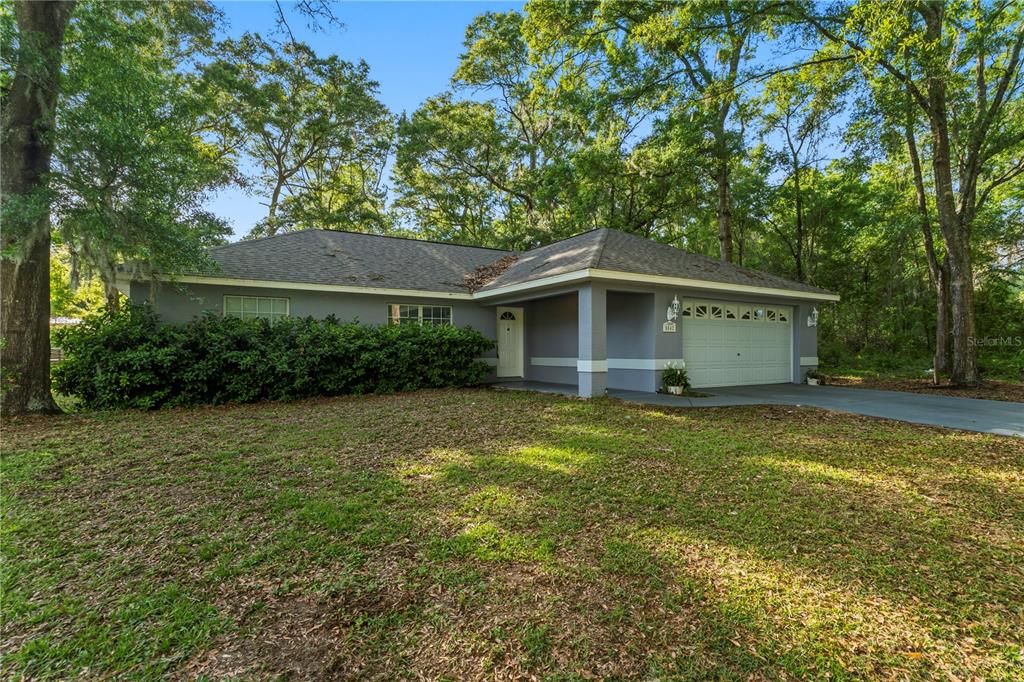 A single-story house with a gray exterior, a two-car garage, and a large front yard — 5542 NW 60TH TERRACE, OCALA, FL