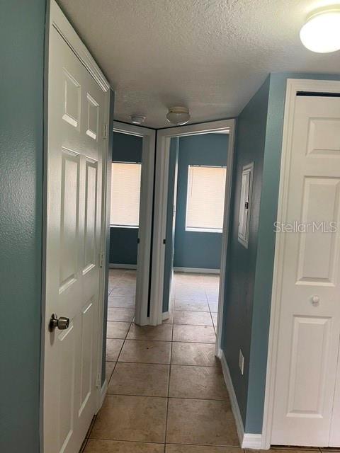A hallway with tile flooring leads to two doorways showing rooms with blue walls — 495 LAS CORTES LANE UNIT 102, ORLANDO, FL