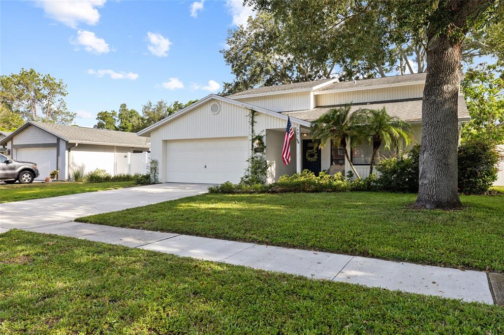 A single-story house with white vertical siding, a two-car garage, and a front lawn — 4814 FOX HUNT DR, TAMPA, FL