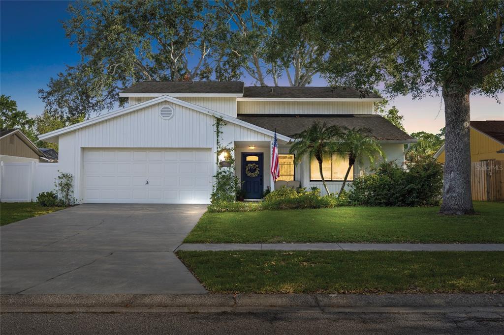 A two-story house with white vertical siding, a two-car garage, and a front lawn — 4814 FOX HUNT DR, TAMPA, FL