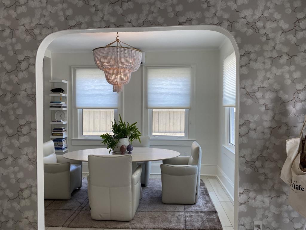 A dining room features a round table, four upholstered chairs, and a beaded chandelier — 5416 4TH AVENUE W, BRADENTON, FL
