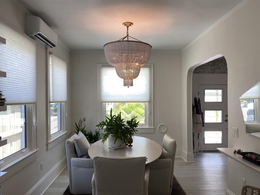 A dining room features a beaded chandelier, a round table, and light-colored tile flooring — 5416 4TH AVENUE W, BRADENTON, FL