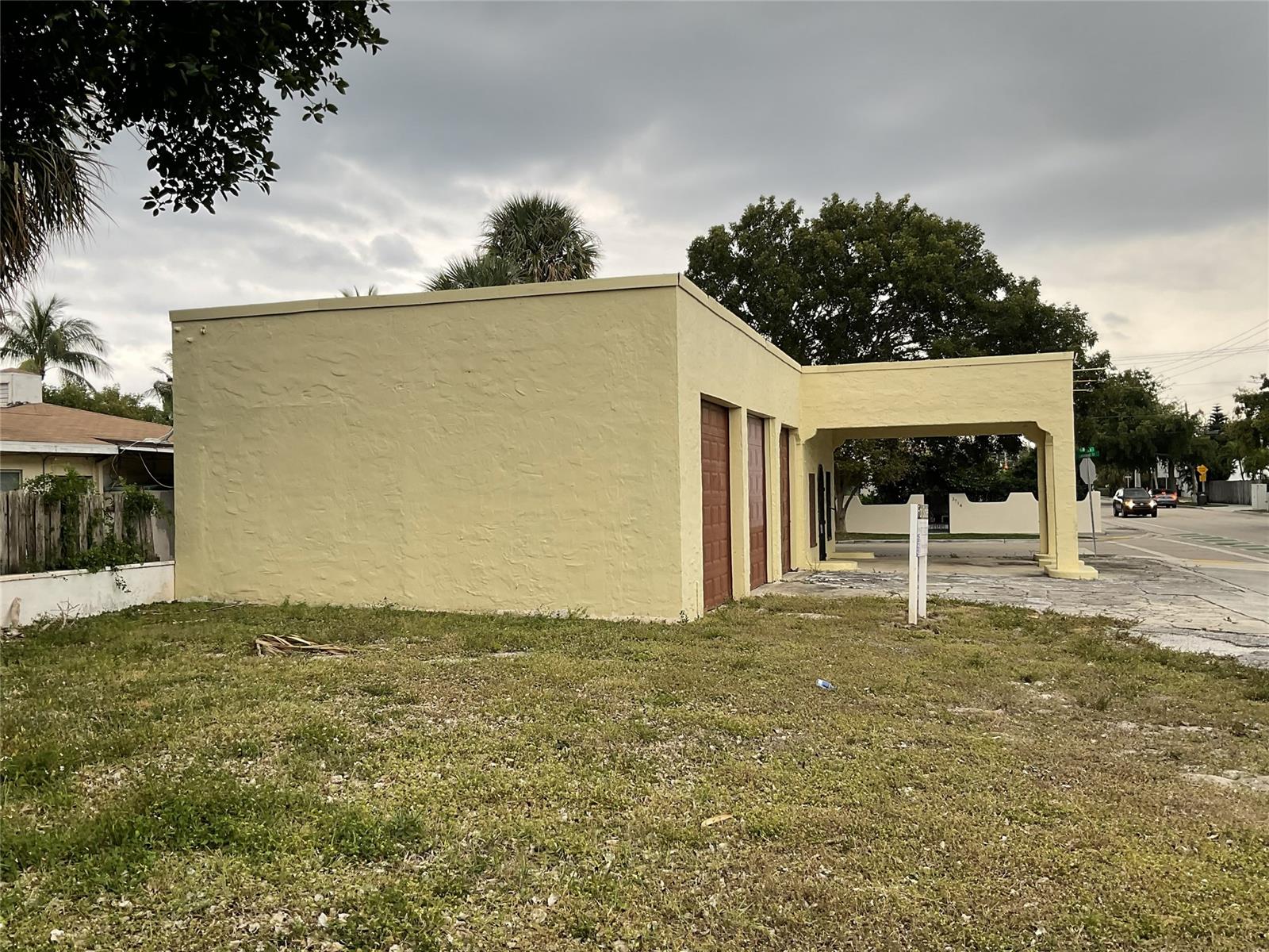 A yellow, flat-roofed commercial building with a covered drive-through area and three garage doors — 3712 S Olive Ave, West Palm Beach FL 33405, WEST PALM BEACH, FL
